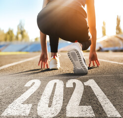 Plakat Start new year with fresh vision and ideas. Sporty woman ready for running near 2021 numbers on road, closeup