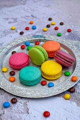Fototapeta na wymiar Top view of colored macarons on a silver platter. Vertical