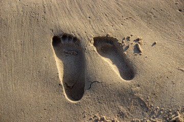 Huellas pies en arena de playa