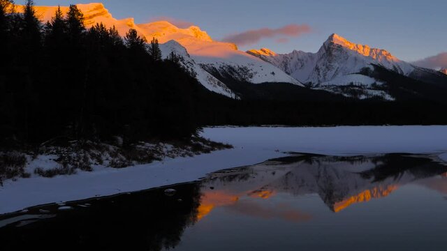 Sunset over the Maligne Lake with Queen Elizabeth Ranges in the background in freezing winter weather. Jasper National Park, Alberta, Canada