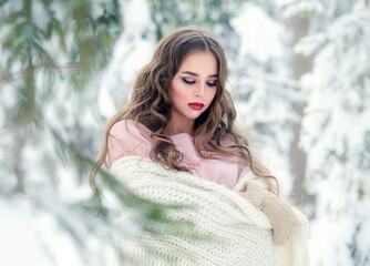 Beautiful romantic woman in a white plaid. Winter beauty portrait in a snow forest