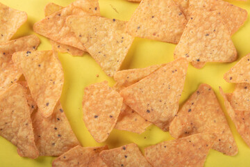 Nachos on yellow background top view.