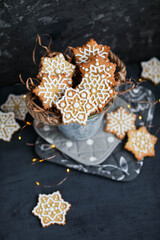 Snowflake cookies in a vintage bucket on a background of garland lights. Christmas and New Year. Gingerbread with glaze.