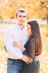 Cute loving couple hugging in the park in autumn