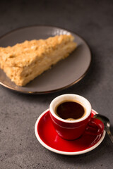 expresso in a red coffee cup with a slice of delicious napoleon cake