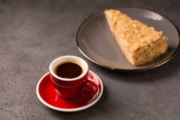 coffee in a red coffee cup with a slice of delicious napoleon cake