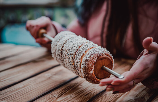 Trdelnik - traditional Czech hot sweet pastry food. outdoors in woman hands