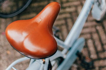 Bike saddle made of brown leather in a blue bike