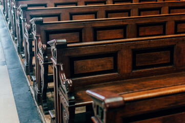 Old wooden benchs located in a church and handcrafted.