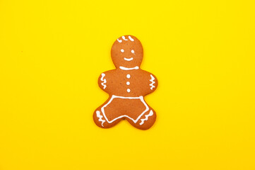 Flat lay of home made gingerbread decorated with icing on yellow background. Winter cookies 