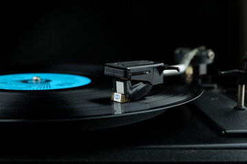 vinyl record on a turntable. turntable head close-up on black background with copy space
