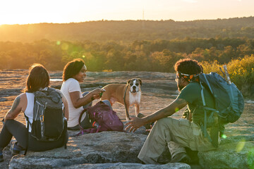 Friends enjoying weekend getaway on mountain top at sunset