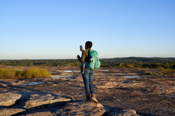 Black woman takes picture of beautiful mountain top view at sunset