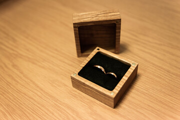 two wedding rings in a wooden square shaped box bride and groom 