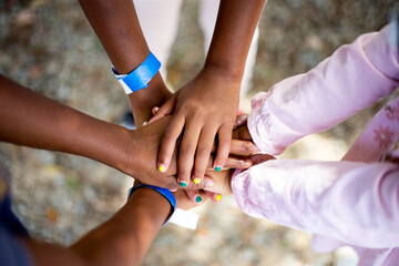 Black kids stacking hands together outdoors in park