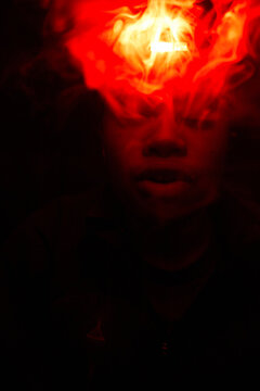 Woman blowing smoke wearing red light
