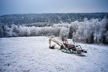 Old tractor sitting in a frozen field. Sørekedalen, Oslo, Norway