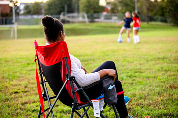 Supportive mom watches daughters play soccer