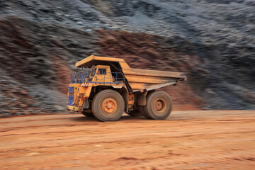 Big mining dump truck rushing at high speed