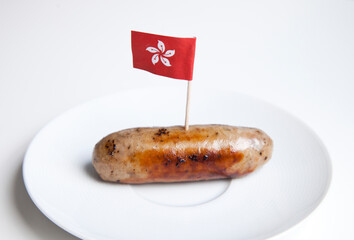 Fried sausage in plate with Hong Kong flag decoration against white background