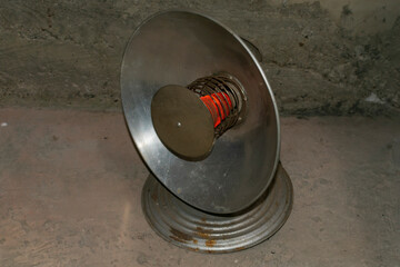 Full-face of an old reflex heater with the heated spiral it is isolated on the black.