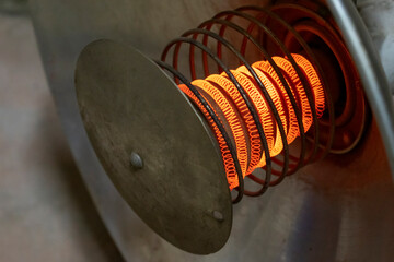 Full-face of an old reflex heater with the heated spiral it is isolated on the black.