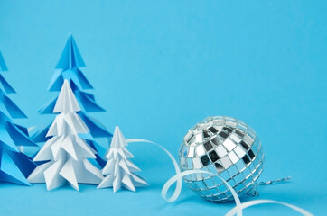 Blue and white paper christmas trees and silver ball composition