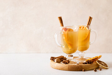 Christmas apple mulled cider with cinnamon and oranges, front view, traditional winter hot holiday...