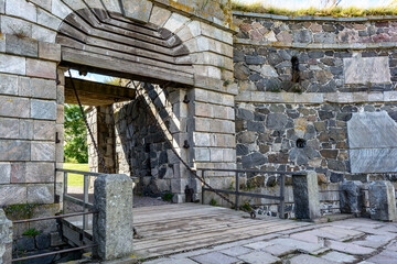 Fototapeta na wymiar The main symbol of Suomenlinna - Kuninkaanportti (King's Gate) - the principal entrance to the fortress. The facade is concave, and the gate, framed with marble stones, is made with rustic masonry.