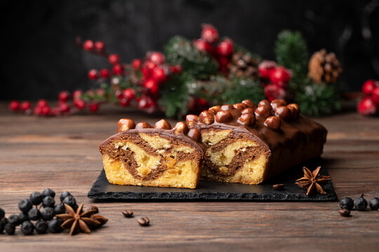 Christmas cake with nuts, biscuit Chocolate Christmas Cake on white plate. Traditional New Year dessert. Copy space   