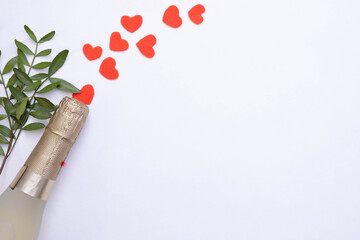 bottle of champagne and red hearts on a white background