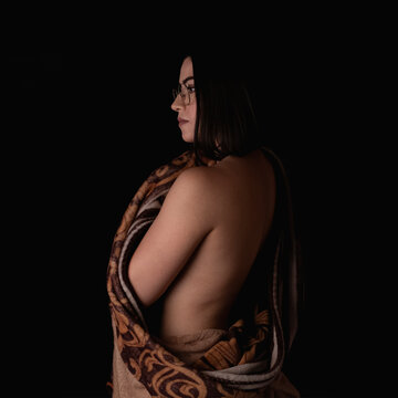 Retrato de mujer joven de espaldas envuelta en una cobija polar