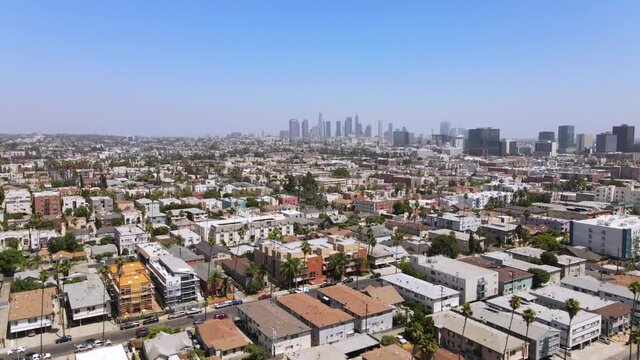 Rising aerial from middle class area near Hollywood, California with downtown Los Angeles in distance.