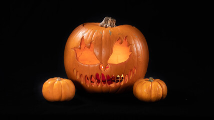 
Illuminated jack o lantern halloween pumpkins, on black background