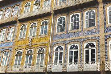 Fototapeta na wymiar facade of a building in Portugal Guimarães ajulejos colorful blue yellow windows 