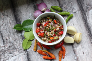 Sambal Jeruk Nipis Or Spicy Lime Sauce with ingredients, Lime, Red Chilies, Green Chilies, garlic, and salt. 