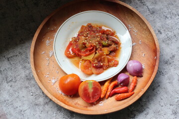 Sambal Tomat Or Indonesian traditional Tomato sauce with ingredients, chilies,  garlic, salt, and tomatoes