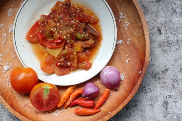 Sambal Tomat Or Indonesian traditional Tomato sauce with ingredients, chilies,  garlic, salt, and tomatoes