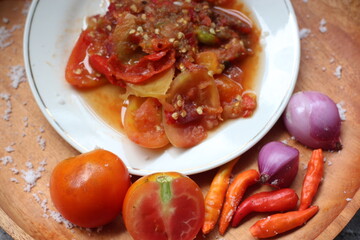 Sambal Tomat Or Indonesian traditional Tomato sauce with ingredients, chilies,  garlic, salt, and tomatoes