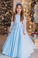Fototapeta premium Little cute happy adorable girl in elegant fashion dress in christmas decorations. Christmas holidays, celebaration concept
