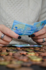 Fototapeta na wymiar manos de mujer contando dinero, monedas y billetes