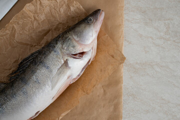 River fish pike perch, whole, cleaned from scales. On baking paper.