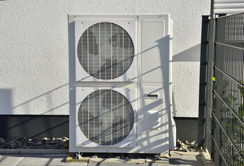 Klimaanlage/Luftwärmepumpe für Heizung und Warmwasser vor einem Wohnhaus