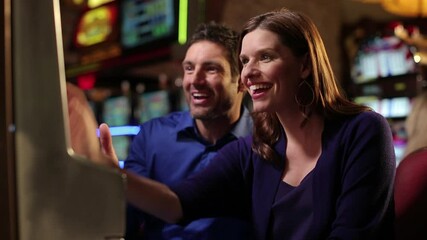 Caucasian couple winning at slot machine