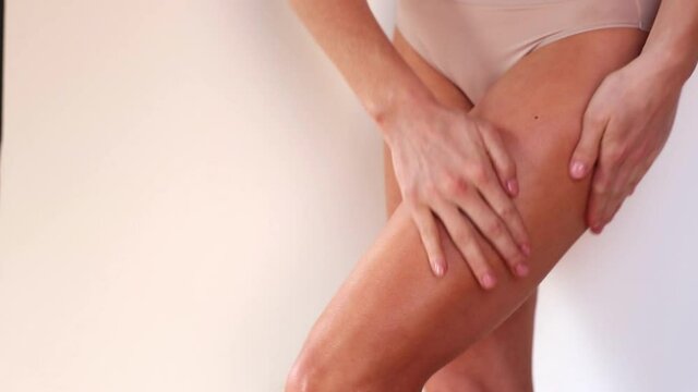 Close up of woman rubbing lotion into leg
