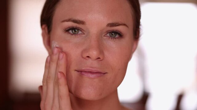 Woman Rubbing Lotion Into Her Face