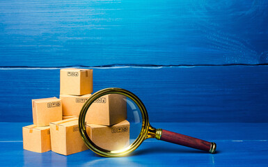 Cardboard boxes and magnifying glass. Concept of searching for goods and components. Procurement...