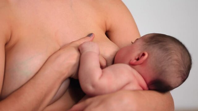 Caucasian woman breastfeeding baby daughter