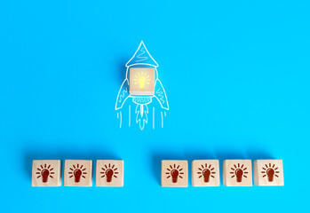 Block with the idea light bulb took off on an imaginary rocket doodle. Developing startup. Choosing...