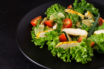Healthy food, salad with chicken, cherry tomatoes, zucchini, arugula and lettuce